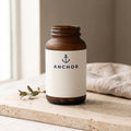 Anchor Gut Health Prebiotic Fiber navy tub on travertine stone with eucalyptus, natural window light
