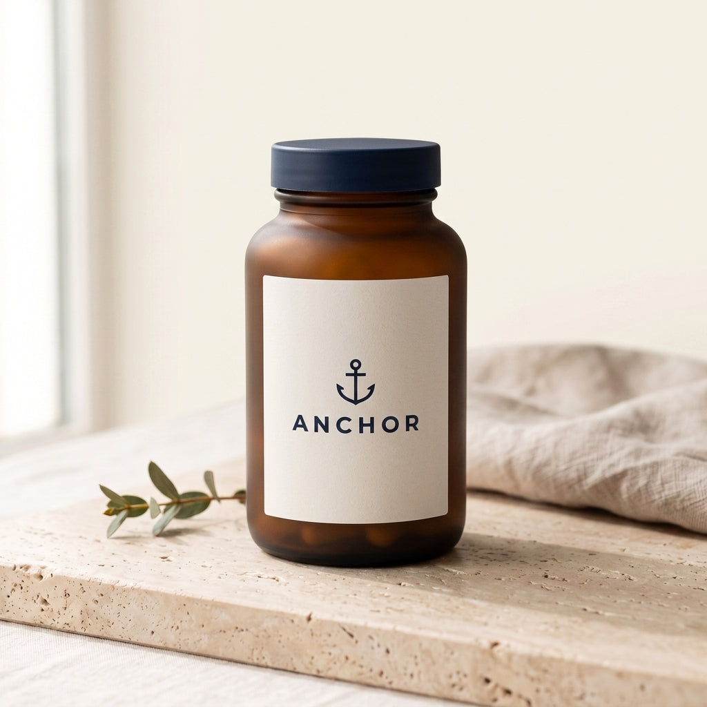 Anchor Complete Multivitamin navy tub on travertine stone with eucalyptus, natural window light